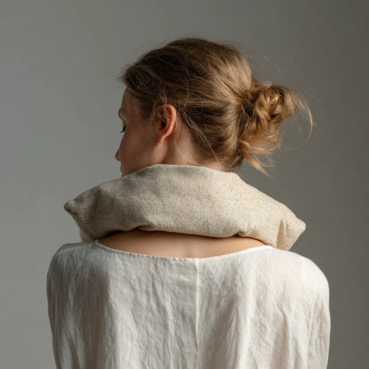 Kauratyyny rentouttavassa käytössä niskan ja hartioiden päällä, luonnollinen pellavapäällinen ja kotimainen luomukaura